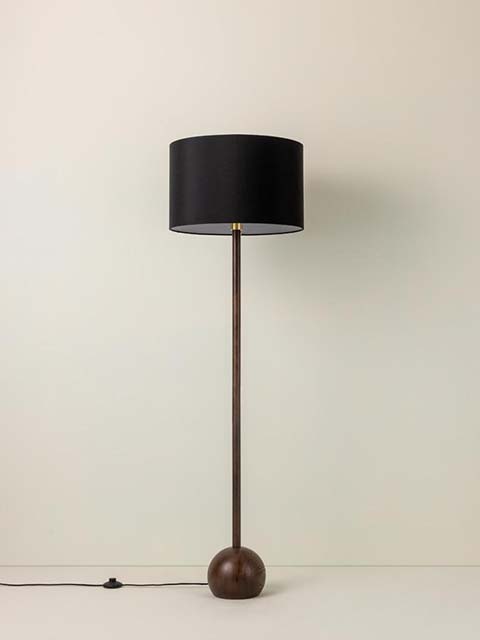 Classic floor lamp with black lamp shade on plain background