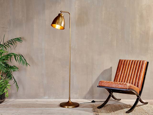 Muturi floor lamp in minimalist lounge with chair and plant, goodhomesmagazine.com