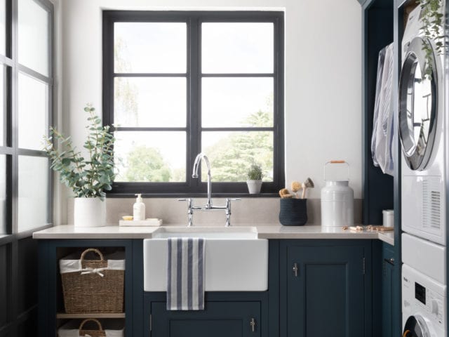 utility room with shaker style cabinets, sink and windows