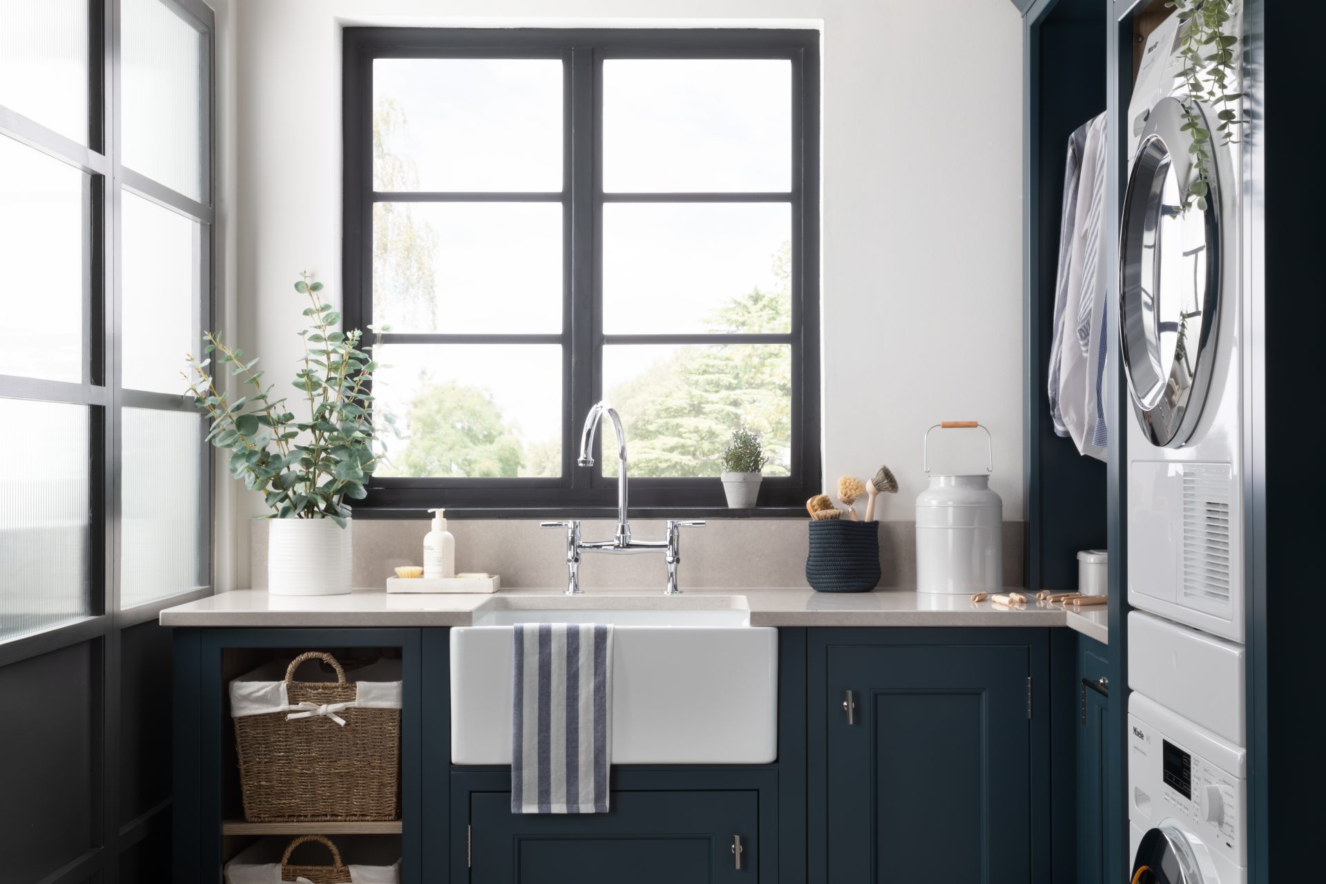 utility room with shaker style cabinets, sink and windows