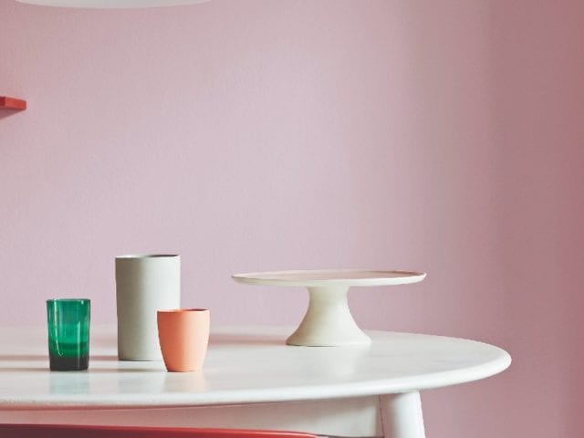 chairs and seats in different colours, in front of red and pink wall