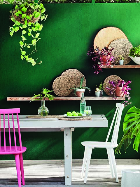 Pink and green dining room with green walls, plant decoration and pink and white chairs, goodhomesmagazine.com