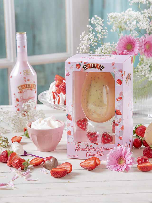 Strawberries surrounding white chocolate Easter egg with pink and white bouquet, goodhomesmagazine.com