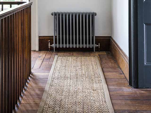 Jute panama runner with cotton herringbone border on wood flooring hallway, goodhomesmagazine.com