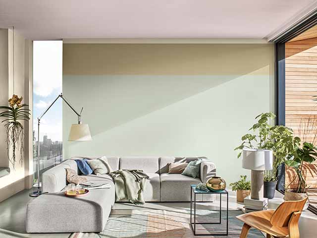 Pastel green living room with corner grey sofa and plants, goodhomesmagazine.com