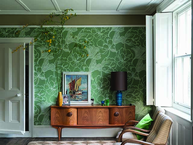 Green wallpaper feature wall in lounge with framed print and oak furniture, goodhomesmagazine.com