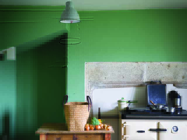Kitchen in bright green with light fitting and woven basket on table, goodhomesmagazine.com