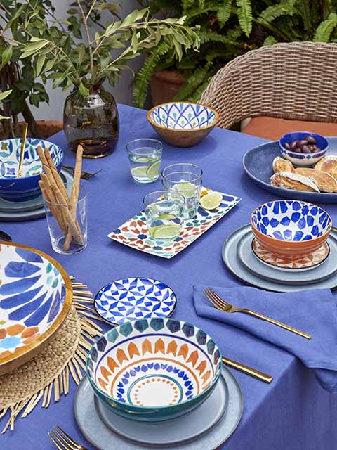 Outdoor table spread with brightly coloured ceramics from John Lewis and Waitrose, goodhomesmagazine.com