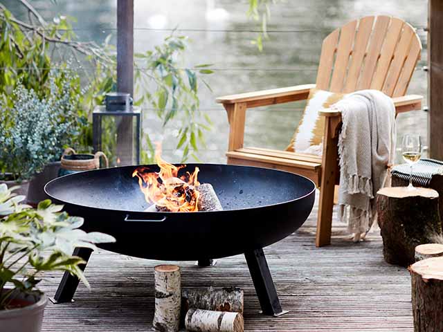 Firepit on balcony with wooden deck chairs, goodhomesmagazine.com