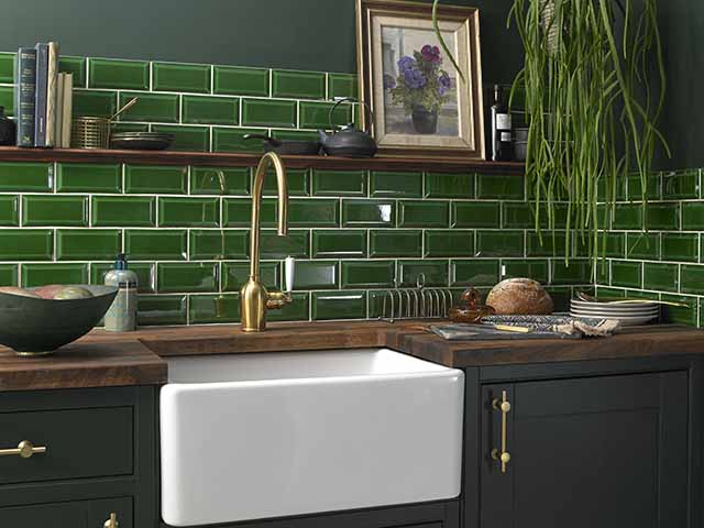 Green tiles in kitchen with gold tap and white basin, goodhomesmagazine.com