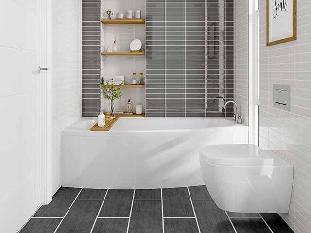 Small bathroom with freestanding bath and grey tiles with bamboo shelves