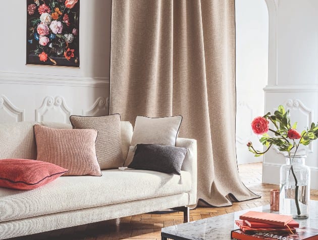 contemporary interior with white sofa, colourful cushions and beige Blinds Direct curtain