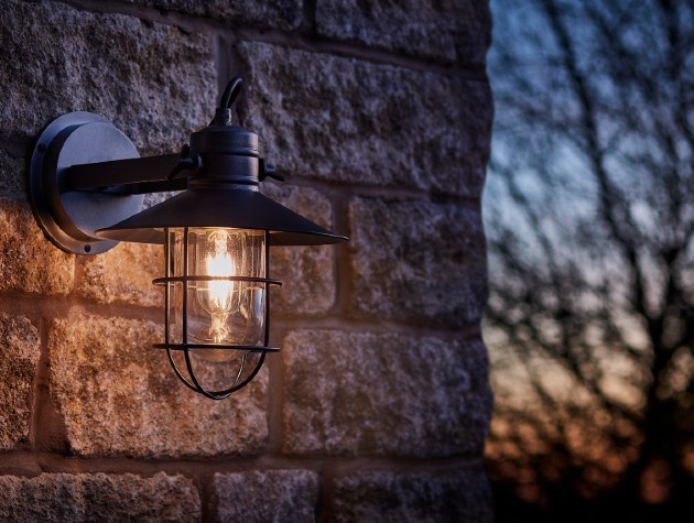 industrial-style light on exterior of house, trees in background