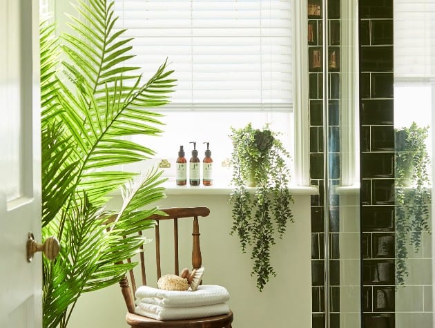 interior of bathroom with plants and Blinds Direct white wooden shutters