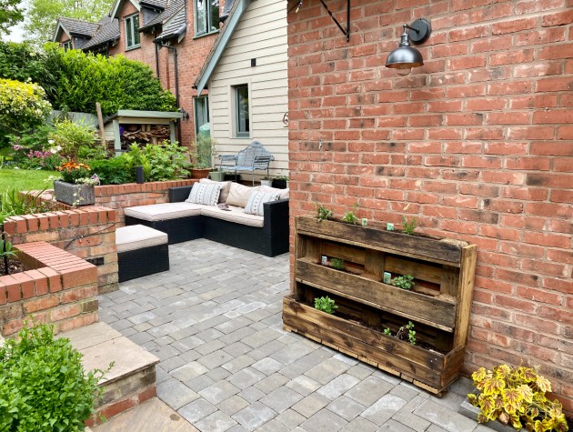 rear of home with patio seating, garden and wooden planter