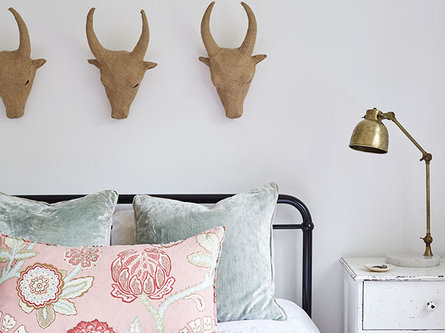 Carved animal heads above double bed with brass lamp in Tunbridge Wells home, Kent, UK. Image: 