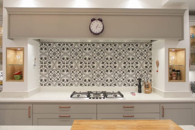 kitchen hob with gas burner and patterned tiled splashback