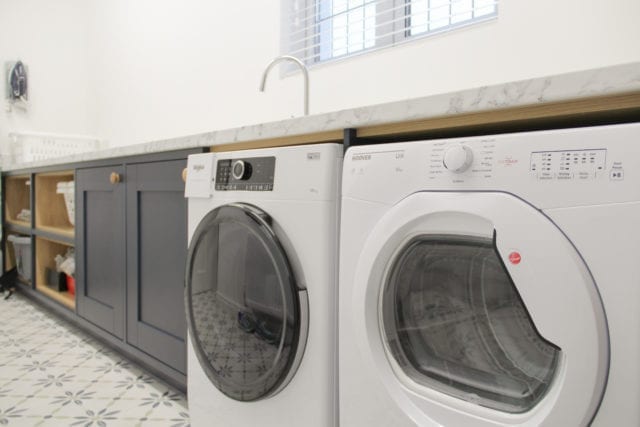 cabinets next to washing machine and tumble dryer in utility room