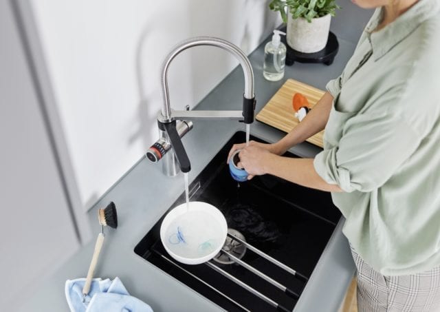 ariel image of a woman washing up with a smart tap