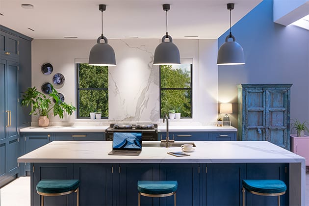 kitchen island with three blue chairs, pendant lighting and laptop