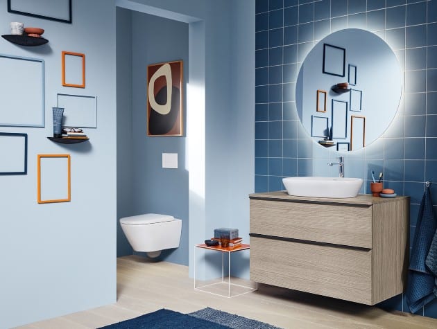 bathroom with blue-painted and tiled walls, sink unit and small toilet
