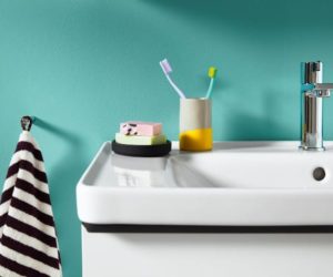 detail of white bathroom sink with soap, toothbrushes and towel