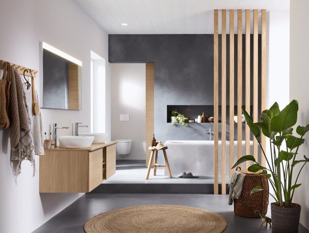 large bathroom with twin sinks, raised bathing area and plants