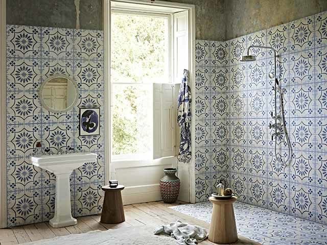 Mediterranean-style bathroom tiles used for the walk-in shower and behind the sink in a large bathroom in a period home with some exposed concrete walls