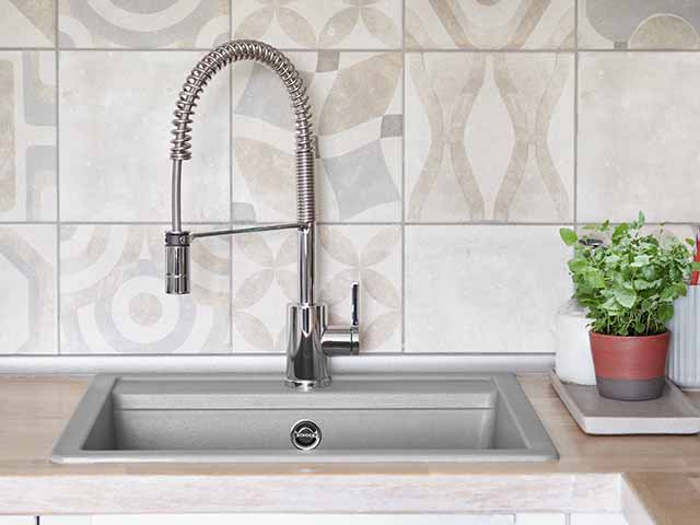 grey kitchen sink in granite composite with patterned splashback tiles