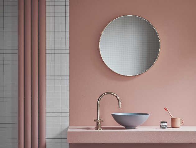 Interior of contemporary bathroom with dusky-pink walls, white square wall tiles and floating vanity countertop