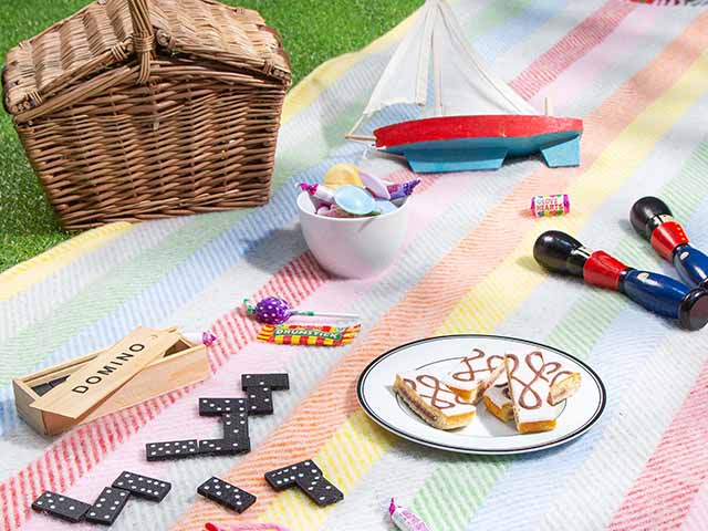 Rainbow picnic blanket with wicker hamper and food