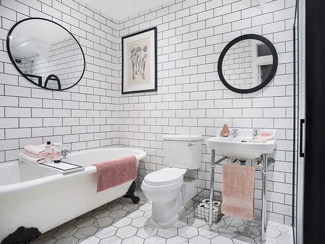white metro tiles in a bathroomwith white hexagon floor tiles and pink towels