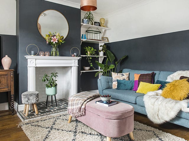 teal living room with period fireplace and alcove shelves and green sofa