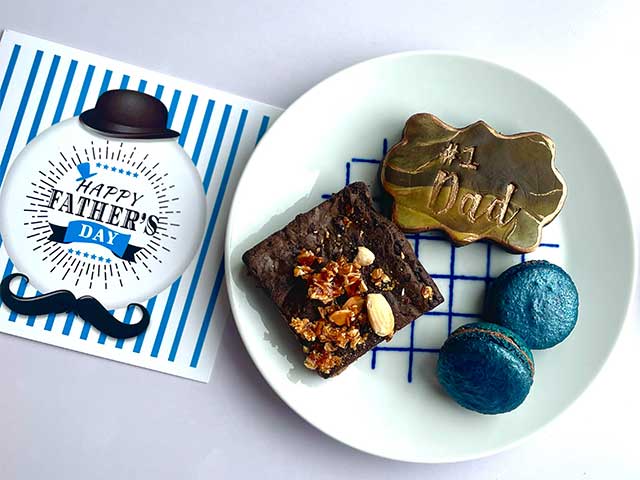 A card reading 'Happy Father's Day' and a plate with a brownie, sweet treat, and two blue macaroons - Father's Day - Goodhomesmagazine.com