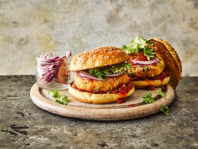 Burgers in seeded buns on a decorative wooden plank - Barbecue recipes - Goodhomesmagazine.com