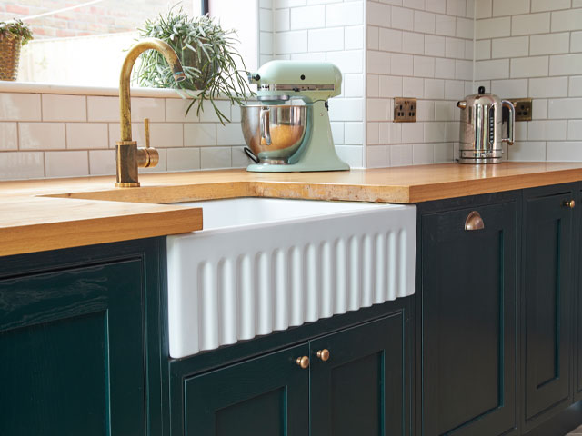 fluted ceramic kitchen sink in white with forest green cabinets
