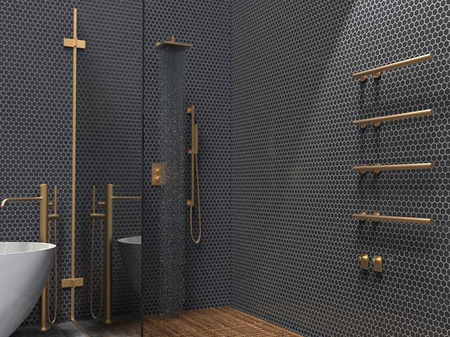 brass heated towel rail in hexagon tiled bathroom with wooden floor