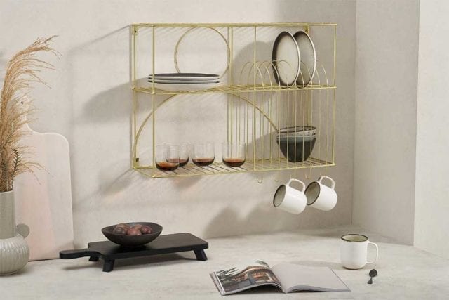 A gold wall-mounted storage rack with crockery and glassware - Small kitchen - Goodhomesmagazine.com