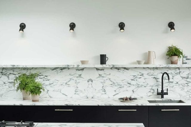 Four separate spotlights on a white wall, above a marble backsplash - Small kitchen - Goodhomesmagazine.com