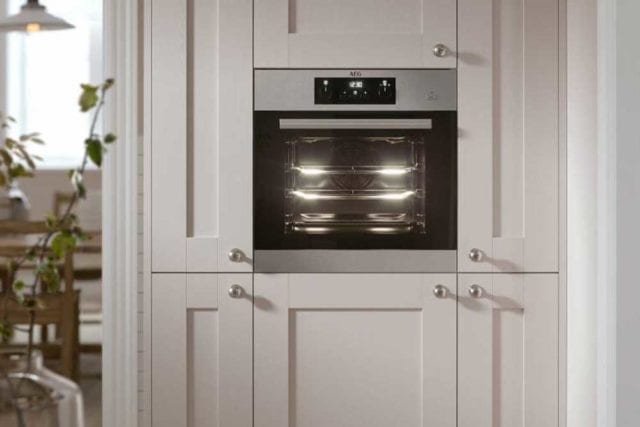 A microwave oven fitted into a cream kitchen cupboard unit - Small kitchen - Goodhomesmagazine.com