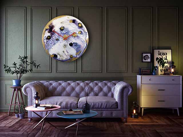 Elegant glass wall clock on panelled wall with retro pincushion settee and side tables in shot, goodhomesmagazine.com