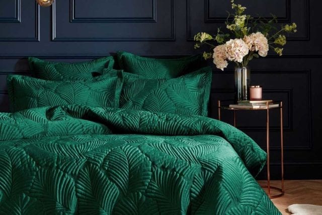 Plush emerald green velvet bedding with a quilter leaf print in a dark painted bedroom - Bold bedding - Goodhomesmagazine.com