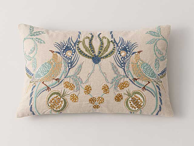 A cream cushion with an embroidered animal pattern - Goodhomesmagazine.com