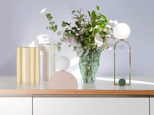 Table lamps on unit with bouquet of flowers in vase, goodhomesmagazine.com
