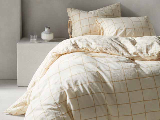 Cream checked organic cotton duvet on double bed in neutral bedroom - Goodhomesmagazine.com
