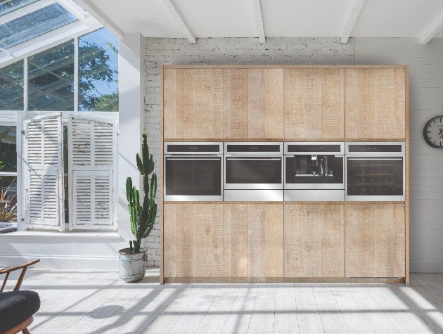 Light contemporary kitchen featuring raw-finished wooden cabinetry with black Caple Sense Premium C2600 oven