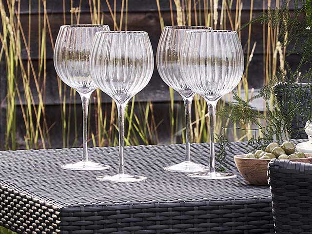flute glasses on rattan black outdoor table, goodhomesmagazine.com
