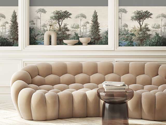 A modern cream sofa in front of a wall with a neutral coloured wallpaper border - Goodhomesmagazine.com