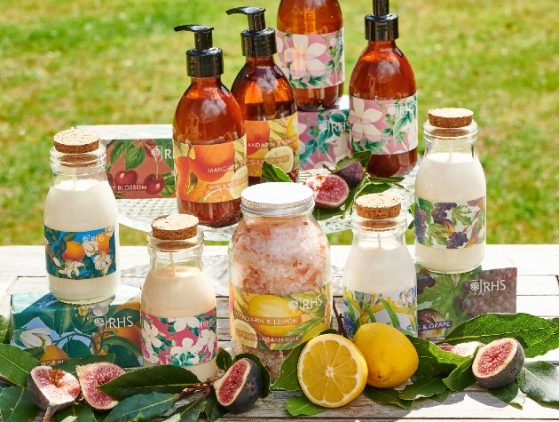 Selection of RHS English Garden bath and bodycare products on a wooden table in the garden