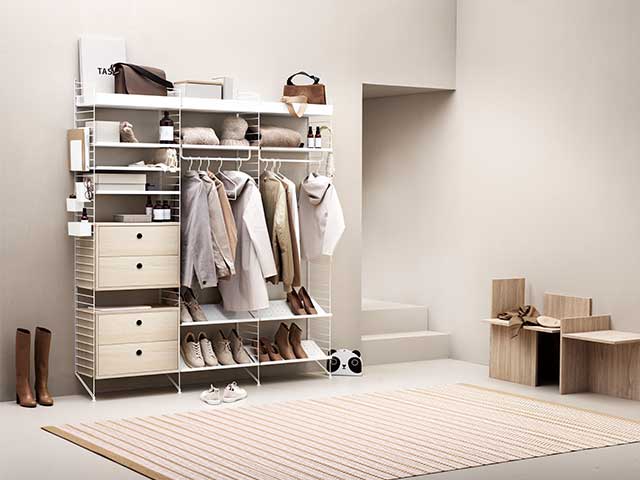 Neutral bedroom with a large modular shelving unit featuring drawers, and hanging clothes - Statement bedrooms - Goodhomesmagazine.com